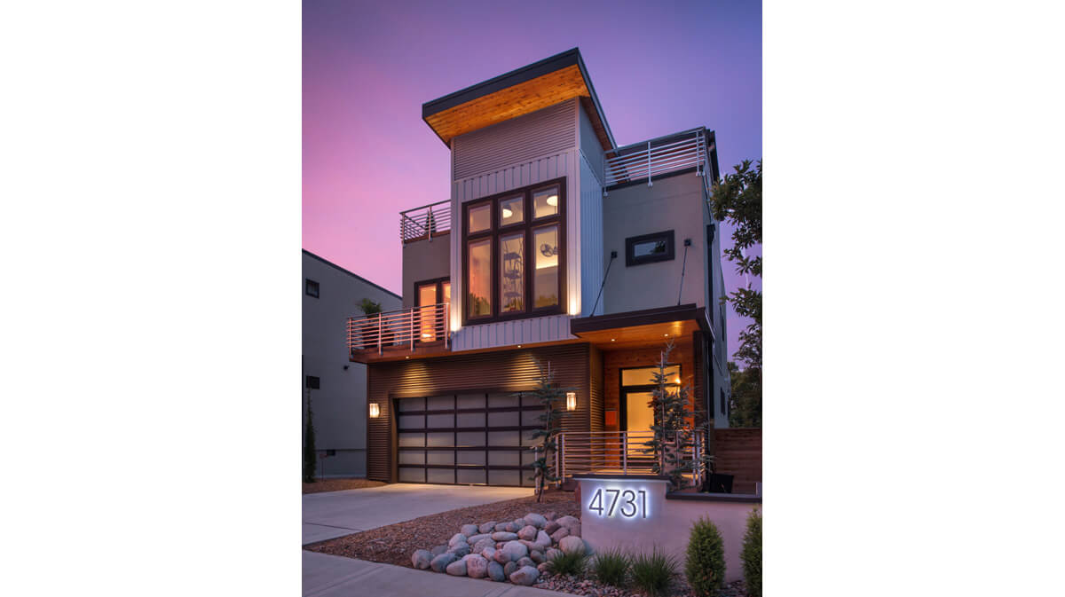 Photograph of view at dusk of front exterior of a two-story modern home in Kansas City, Missouri. Architecture, landscape architecture and interior design by NSPJ Architects.