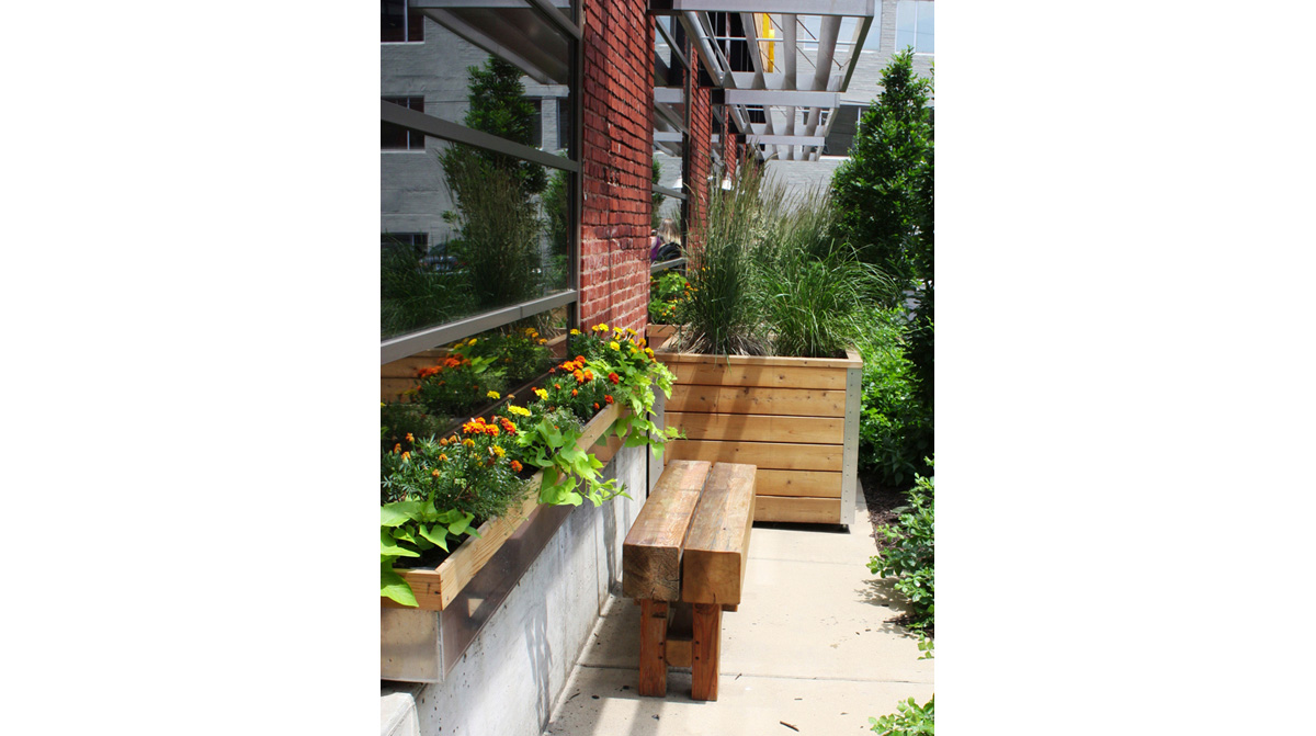 Wooden bench and window boxes with marigolds at downtown Kansas City office. Landscape architecture by NSPJ Architects.